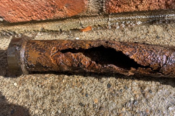 Corroded old metal pipe section removed during repair
